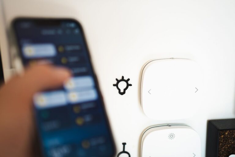Hand bedient een smartphone-app naast slimme apparaten aan de muur