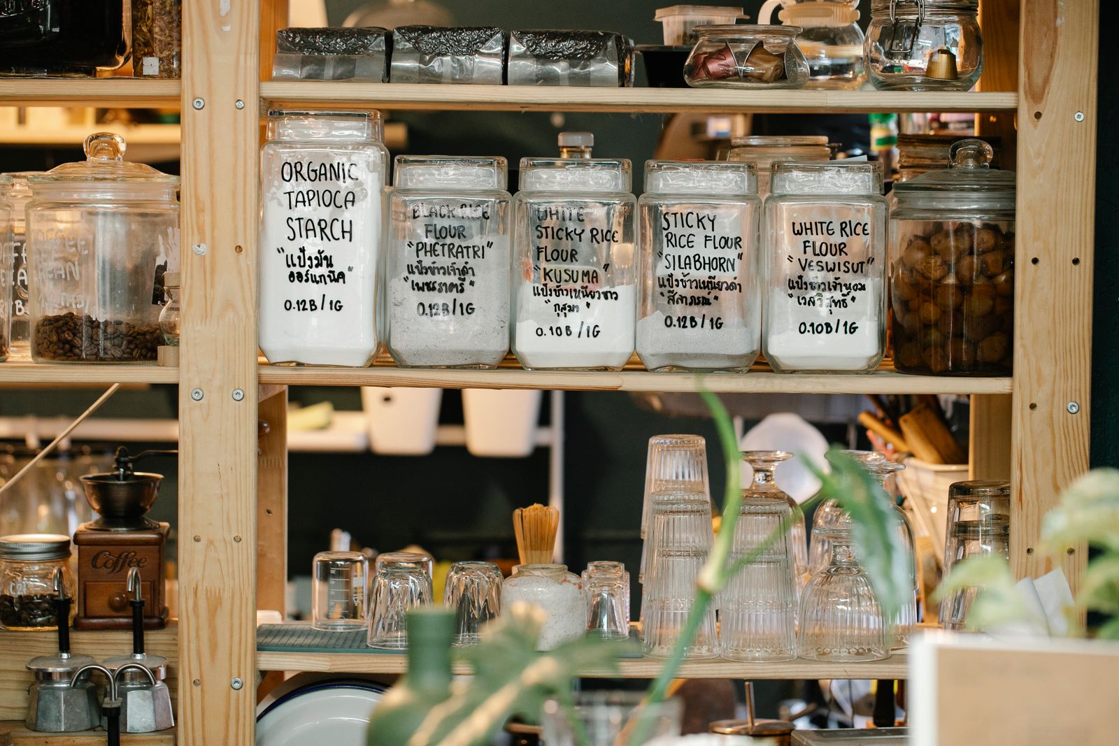 Glazen potten met droge voeding op een plank in de keuken