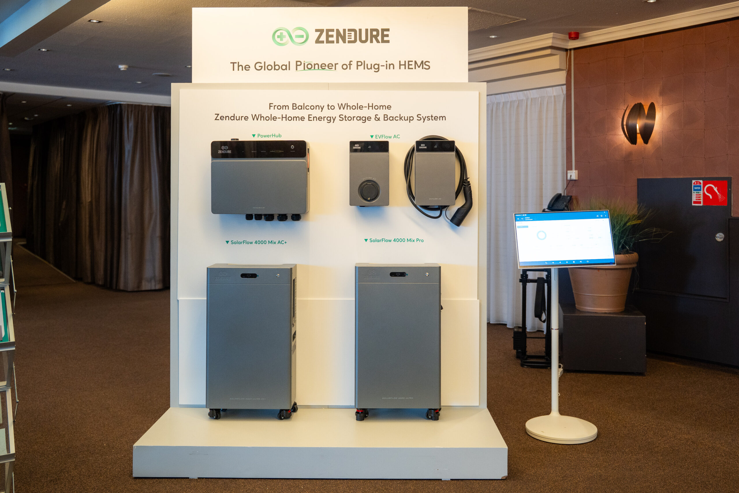 Zendure PowerHub met laadpalen en daaronder de SolarFlow 4000 Mix AC+ en SolarFlow 4000 Mix Pro op een presentatiewand